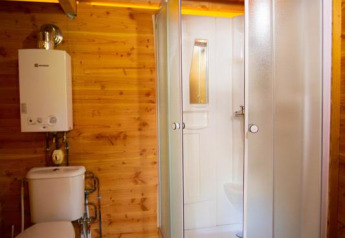 Houten badkamer met douche en toilet in een safaritent genaamd Cabane bij Bivouac nature in Frankrijk.