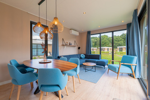 Stylish living and dining area in Water lodge 6 Deluxe at Hofparken Wiltershaar in the Netherlands, blue decor.