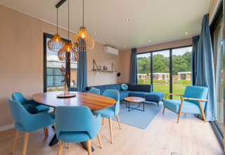 Stylish living and dining area in Water lodge 6 Deluxe at Hofparken Wiltershaar in the Netherlands, blue decor.