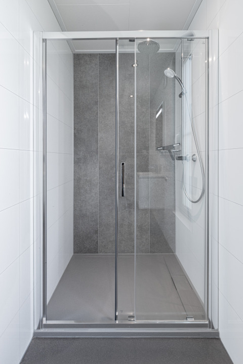Cabine de douche moderne avec portes en verre et carrelage gris à Parklodge 6, Hofparken Wiltershaar.