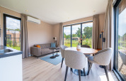 Helles Wohnzimmer in der Water lodge 2 Deluxe mit Sauna und Whirlpool, große Fenster und Naturblick bei Hofparken Wiltershaar.