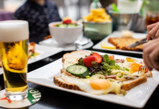 Een smakelijk ontbijt met toast, eieren, groenten en bier, geserveerd in Holiday Park Gelloo, Gelderland.
