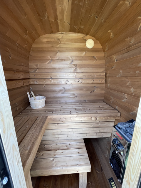 Intérieur d’un sauna en bois à Berg Lodge, Resort Mooi Bemelen, Pays-Bas, avec bancs et poêle.