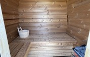 Interieur van een houten sauna bij Berg Lodge, Resort Mooi Bemelen in Nederland, met banken en kachel.
