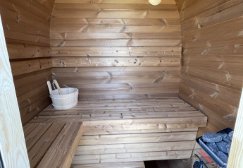 Interior of a wooden sauna at Berg Lodge, Resort Mooi Bemelen, Netherlands, showing benches and heater.