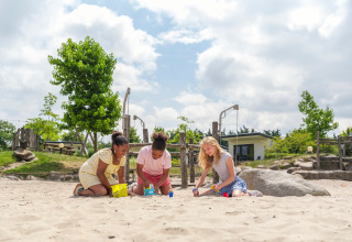 Tre bambini giocano insieme nella sabbia in un parco giochi di Holiday park Ackersate, Gelderland, Paesi Bassi.