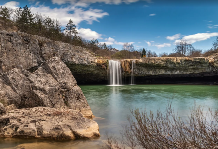 Suggestiva cascata vicino a Tar, Istria, Croazia, che scorre tra rocce e natura sotto il cielo azzurro.