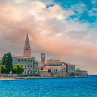Vista costiera su edifici storici e campanili vicino a Tar, Istria, Croazia, sotto un cielo variopinto.