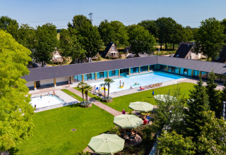 Gezicht op het zwembad en vakantiehuisjes van Hof van Salland, een vakantiepark in Overijssel, Nederland.