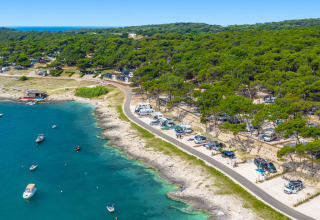Camping Arena Stupice holiday park in Istria, Croatia, with campers by the sea and boats on blue water.
