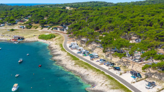 Camping Arena Stupice feriepark i Istrien, Kroatien med campingvogne ved kysten og både i blåt hav.
