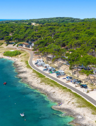 Camping Arena Stupice feriepark i Istrien, Kroatien med campingvogne ved kysten og både i blåt hav.