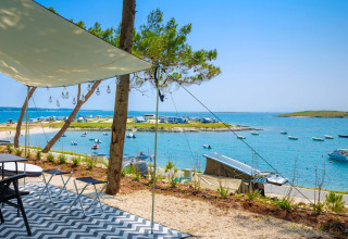 Blick auf das Meer und den Campingplatz Arena Stupice in Istrien, Kroatien, mit Booten und Sonnensegel.
