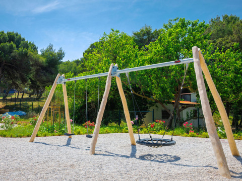 Balançoires de terrain de jeu sous les arbres au Camping Arena Stupice, Istrie, Croatie, par beau temps.