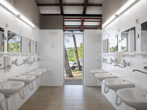 Communal washroom with several sinks and mirrors at Camping Arena Stupice holiday park in Istria, Croatia.