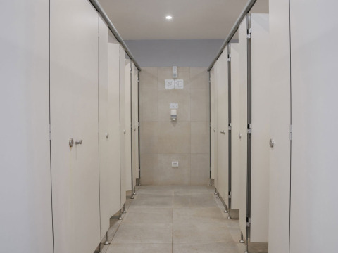 A modern communal bathroom with multiple closed toilet stalls at Camping Arena Stupice, Istria, Croatia.