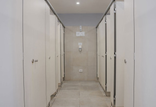 A modern communal bathroom with multiple closed toilet stalls at Camping Arena Stupice, Istria, Croatia.