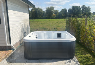Bubbelbad naast Wilbrink chalet bij Vakantiepark De Boshoek in Nederland, met uitzicht op het weiland.