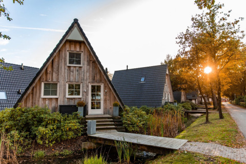 A-förmige Ferienhäuser im Sonnenuntergang im Ferienpark Hof van Salland, Overijssel, Niederlande.
