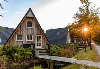 Gezellige A-vormige vakantiehuisjes bij zonsondergang in Hof van Salland, Overijssel, Nederland.