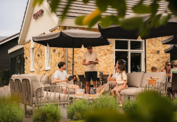 Outdoor seating at Berg Lodge - Sauna at Resort Mooi Bemelen, Netherlands, with people socializing.