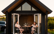 Deux personnes se détendent sur la terrasse de Berg Lodge - Sauna au Resort Mooi Bemelen aux Pays-Bas.