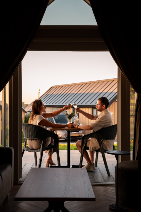 Couple trinque avec du vin lors d'un dîner à la Berg Lodge - Sauna au Resort Mooi Bemelen, Pays-Bas.
