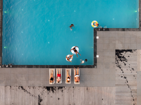 Luchtfoto van een zwembad met zwemmers en zonaanbidders bij Berg Lodge - Sauna in Resort Mooi Bemelen.