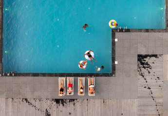 Aerial view of a pool with people swimming and sunbathing at Berg Lodge - Sauna at Resort Mooi Bemelen.