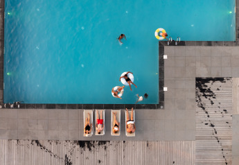 Luchtfoto van een zwembad met zwemmers en zonaanbidders bij Berg Lodge - Sauna in Resort Mooi Bemelen.