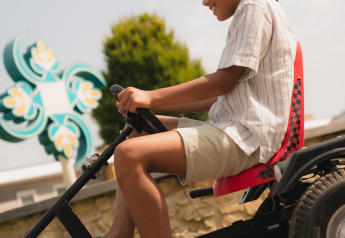 Young boy riding a go-kart at Biebosch lodge in Resort Mooi Bemelen, Netherlands, on a sunny day.