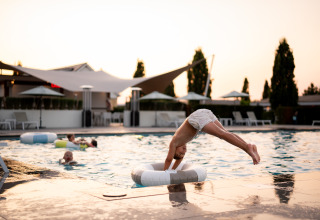 Dreng dykker i swimmingpool ved Biebosch - tuinhuis, Resort Mooi Bemelen, Holland, med flere børn i vandet.