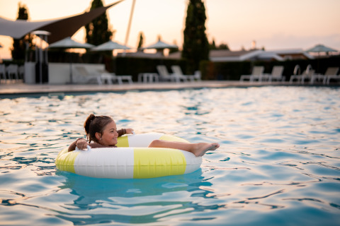 Una ragazza si rilassa su un gonfiabile nella piscina di Biebosch - Sunshower, Resort Mooi Bemelen, Paesi Bassi.