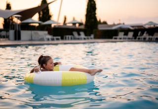 Una ragazza si rilassa su un gonfiabile nella piscina di Biebosch - Sunshower, Resort Mooi Bemelen, Paesi Bassi.