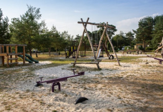 Parque infantil al aire libre con columpios, toboganes y balancines en Camping GT Keiheuvel, Amberes, Bélgica.