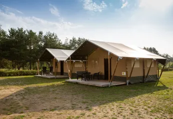 Due grandi tende safari con veranda esterna al Camping GT Keiheuvel in Belgio, in un ambiente verde e soleggiato.