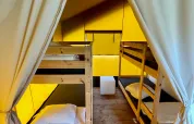 Interior of a Safaritent at Camping GT Keiheuvel in Belgium, featuring bunk beds and wooden flooring.