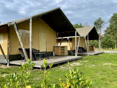 Tentes safari au Camping GT Keiheuvel en Belgique, avec terrasses surélevées et mobilier de jardin en plein air.