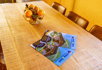 Wooden table with easyTent brochures and a fruit bowl at Bijela Uvala Safaritent Lodge, Camping Bijela Uvala, Croatia.