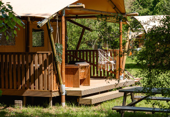 Safari glamping telt La Vida på Resort de Parel i Holland, omgivet af grønt og udendørs siddepladser.