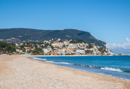 Coastal town with a beach and hills in the background near Castelleone di Suasa, Marche, Italy on a clear day.