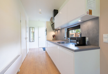 Strakke moderne keuken in Vakantievilla Amalia 6 met zicht op raam te Hofparken De Bergvennen, Nederland.