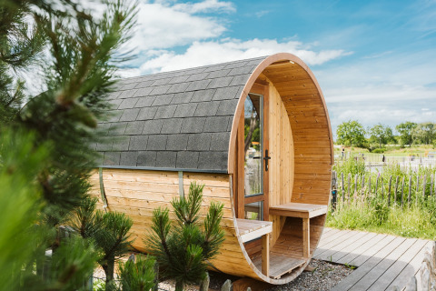 Houten vakantieaccommodatie in tonvorm bij vakantiepark De Klepperstee, Zuid-Holland, Nederland, in de natuur.