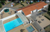 Vista aerea di Flower Camping Le Pré des Sables con piscina, parco giochi e alloggi in Francia.