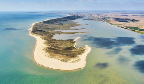 Vista aérea de la costa cerca de L'Aiguillon-sur-Mer en Pays de la Loire, Francia, con playas y mar.
