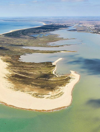 Aerial view of the coastline near L'Aiguillon-sur-Mer in Pays de la Loire, France, showing sandy shores.