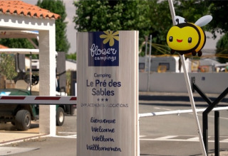 Ingang van Flower Camping Le Pré des Sables met welkomstbord en schattige bijendecoratie in Pays de la Loire.