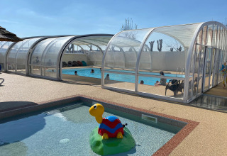 Overdekt zwembad en kinderbad met schildpad-speelgoed bij Flower Camping Le Pré des Sables, Pays de la Loire.
