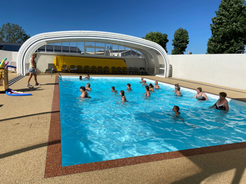 Persone partecipano a una lezione di acquagym nella piscina coperta di Flower Camping Le Pré des Sables, Francia.
