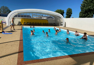 Persone partecipano a una lezione di acquagym nella piscina coperta di Flower Camping Le Pré des Sables, Francia.